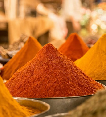 A close-up view of colorful powdered spices on display at a market stall.
